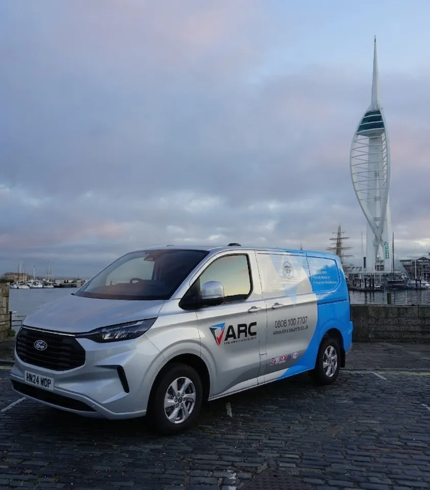 ARC branded service van parked on a cobbled waterfront area, with marina boats in the background and the Spinnaker Tower visible under a cloudy sky.